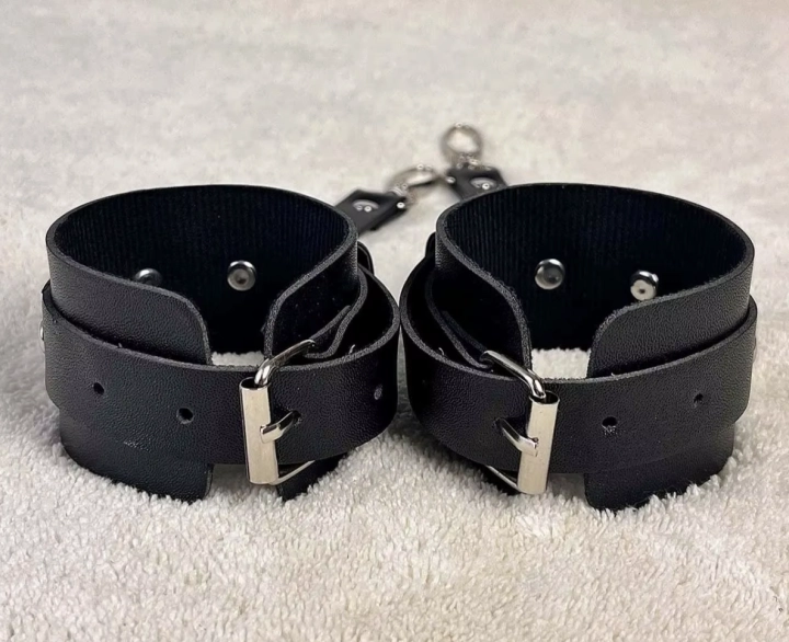 Regulowane kajdanki na ręce w kolorze czarnym. Miękki materiał, metalowe zapięcia, wygodne dopasowanie. Obwód 17,5–27,5 cm. Dyskretny i komfortowy model.